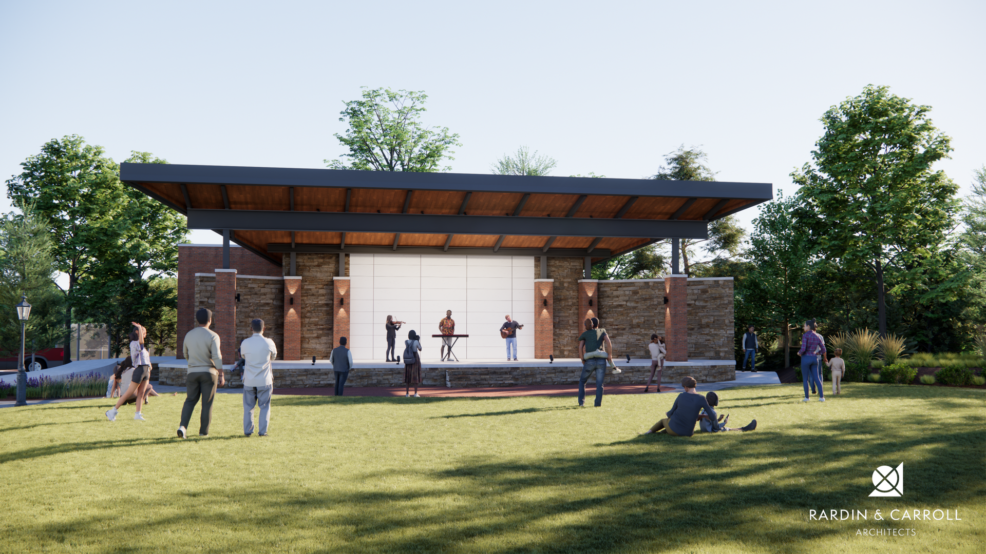 Outdoor pavilion stage in a park with people gathered on the lawn and performers onstage