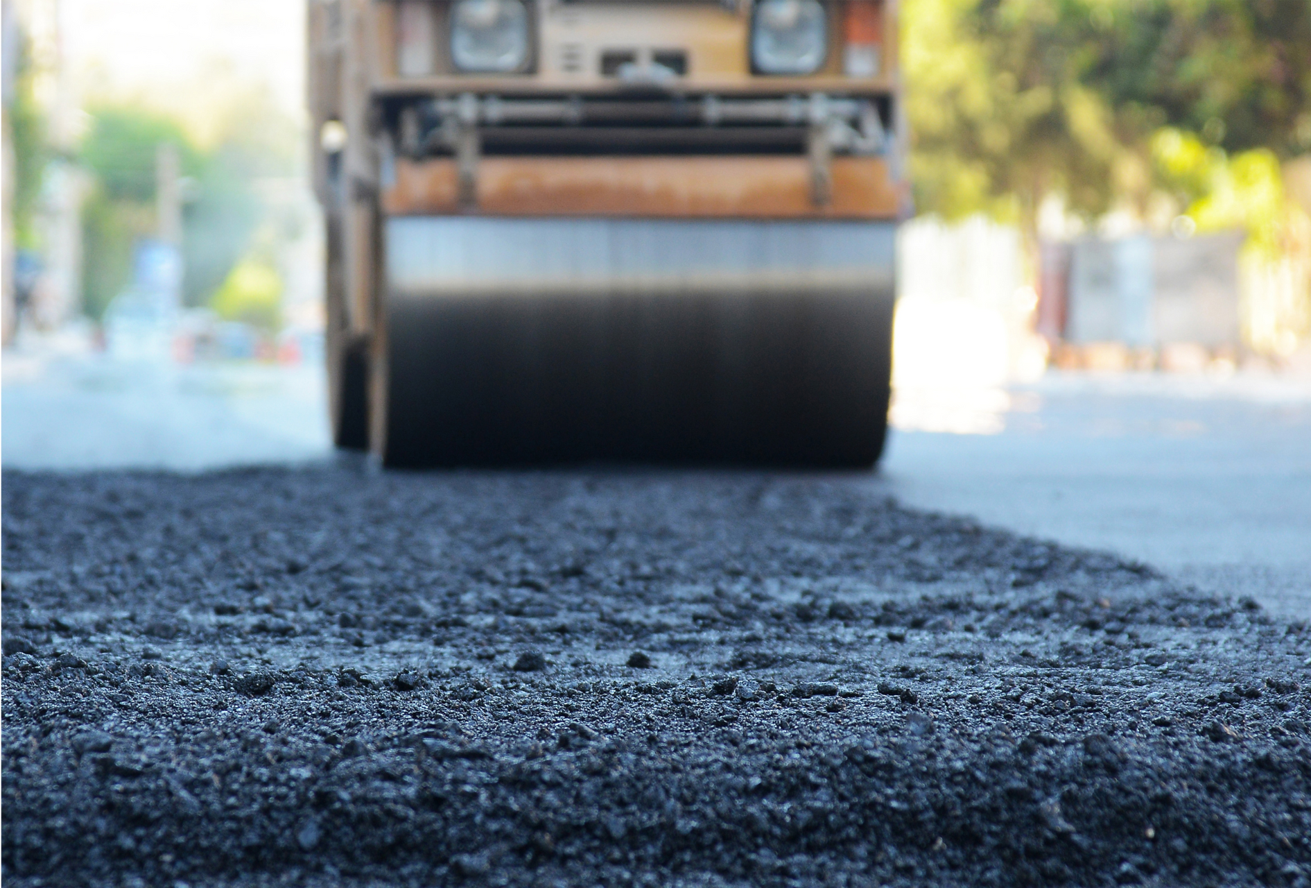 Road roller paving fresh black asphalt on a street