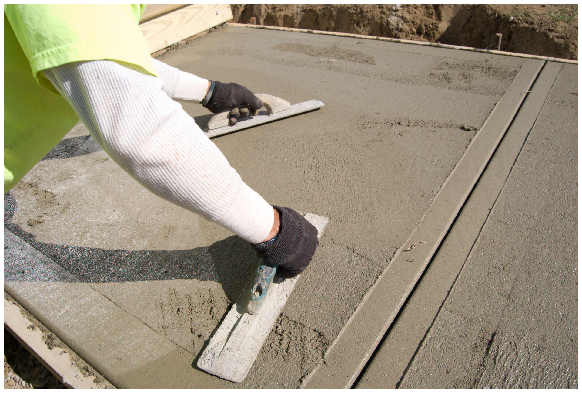 Worker smoothing fresh concrete with a trowel on a sidewalk slab