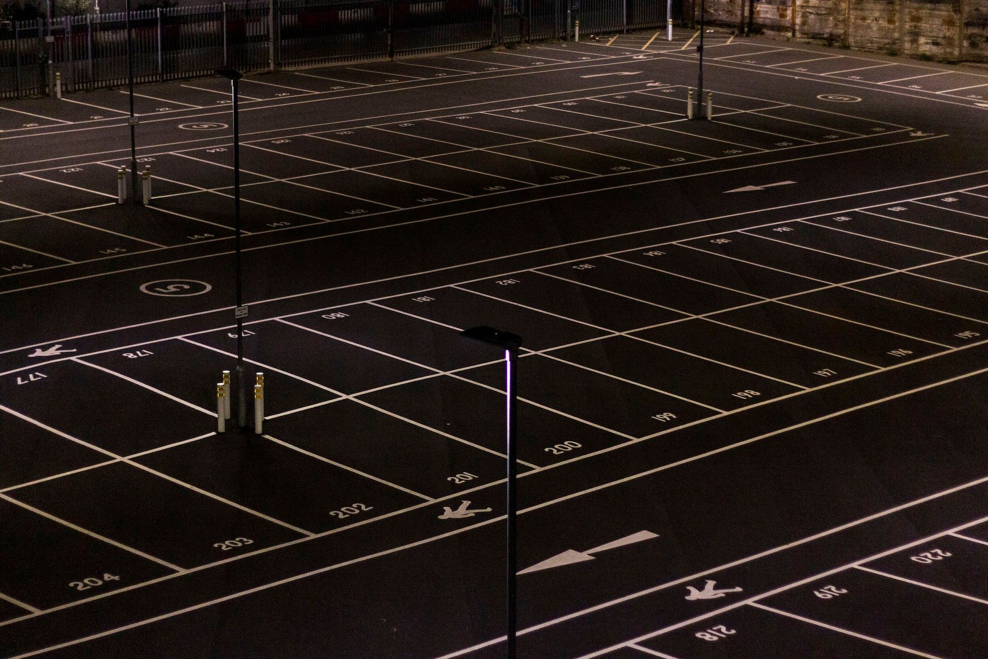 Dark urban plaza at night with a grid of small white lights embedded in the pavement