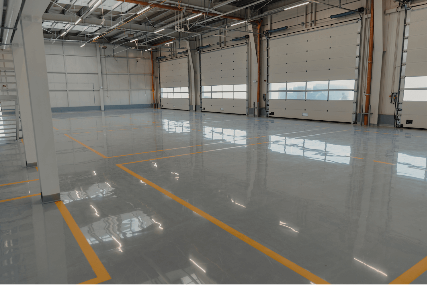 Empty industrial warehouse interior with polished concrete floor and yellow lane markings