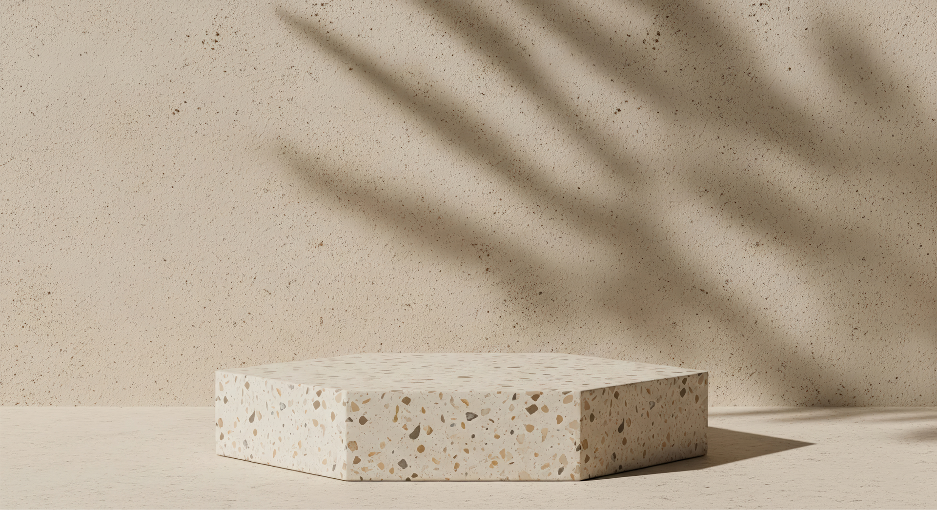 Beige speckled pedestal block on a light wall with soft diagonal shadows
