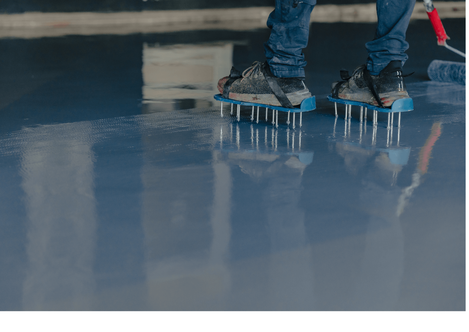 Two people wearing ice cleats stand on a wet, reflective icy surface.