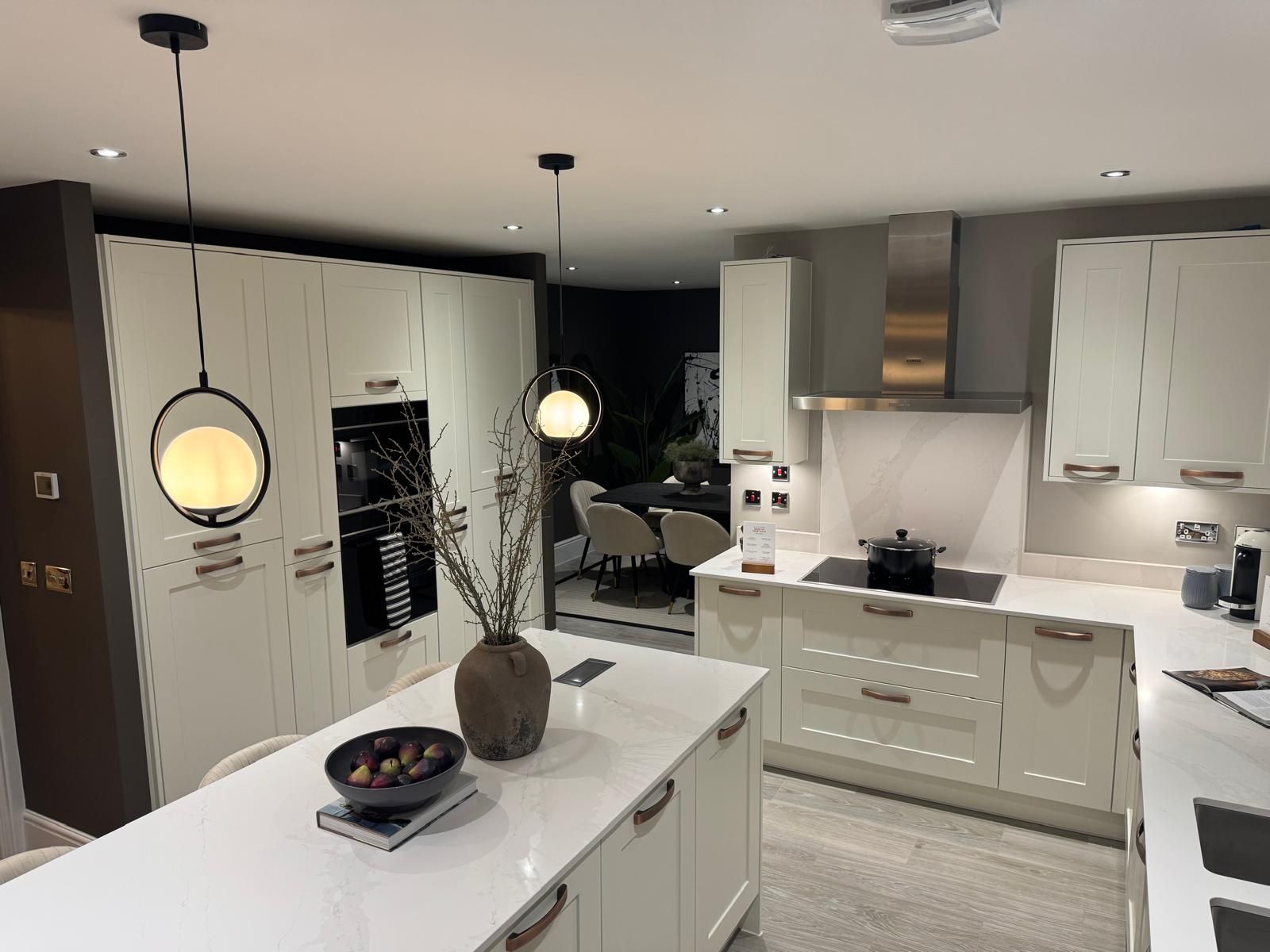 Modern kitchen project in Fareham with cream cabinets, white countertops, and decorative pendant lights.