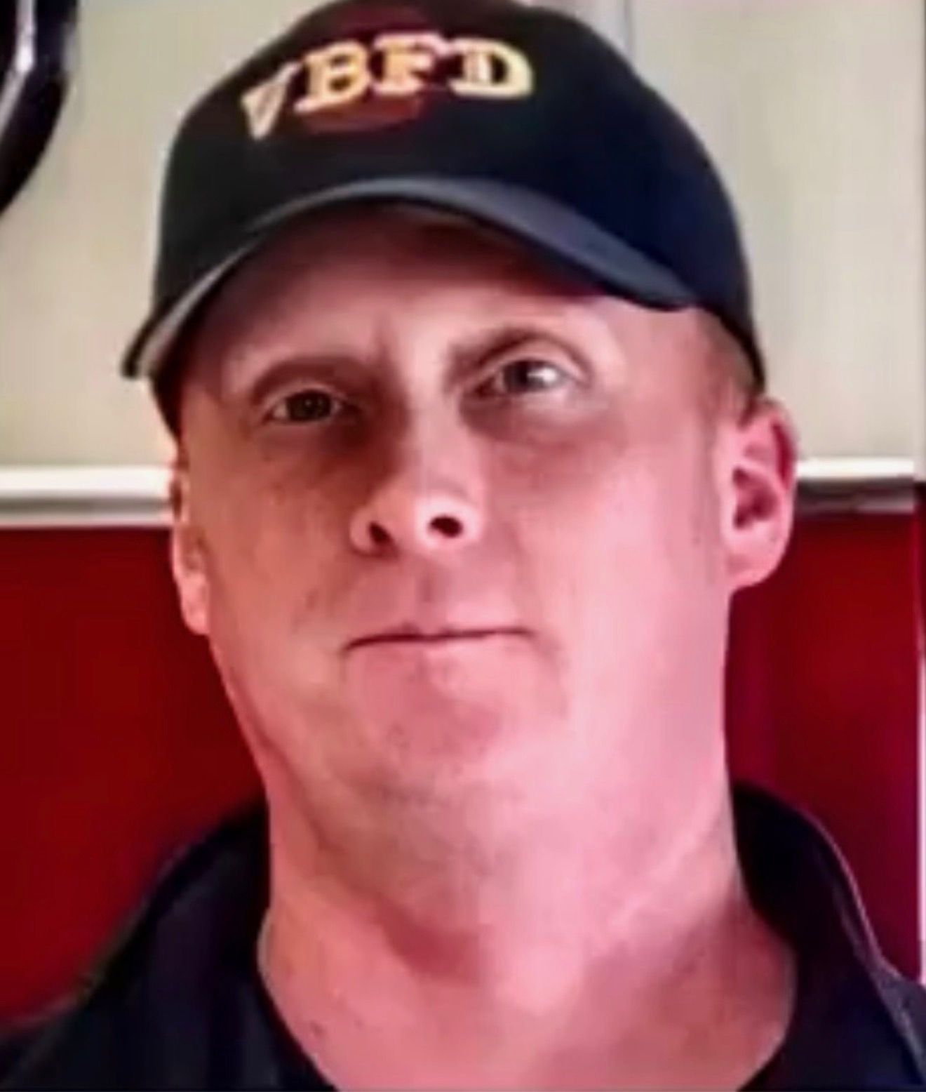 Man wearing a black VBFD cap, facing forward against a white and red background.