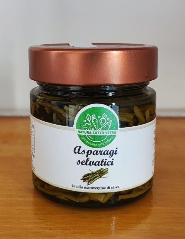 Piccolo barattolo di vetro con coperchio in rame con etichetta “Asparagiverde” su una superficie di legno