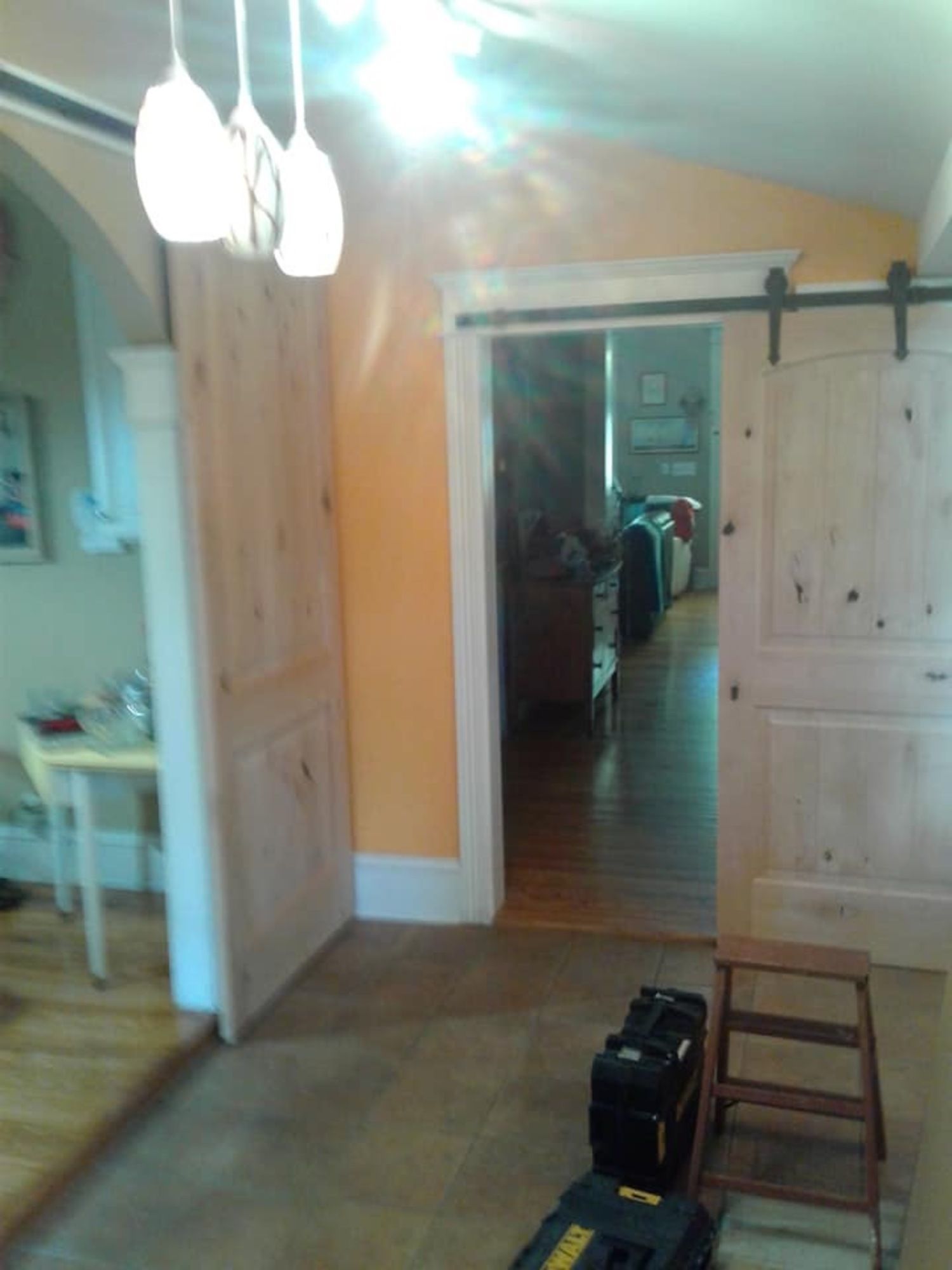 a room with a sliding barn door and a stool