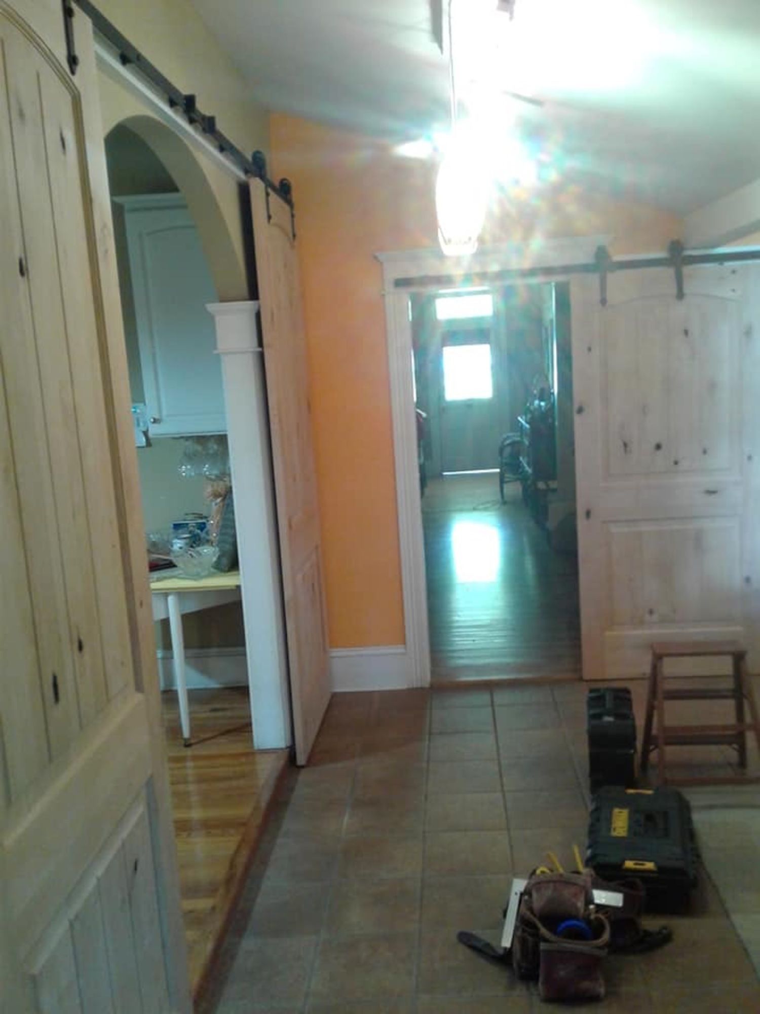 a hallway with sliding barn doors leading to a kitchen .