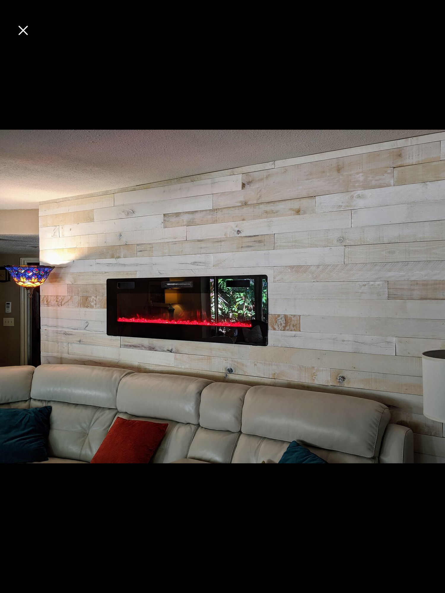 a living room with a couch and a fireplace on the wall .