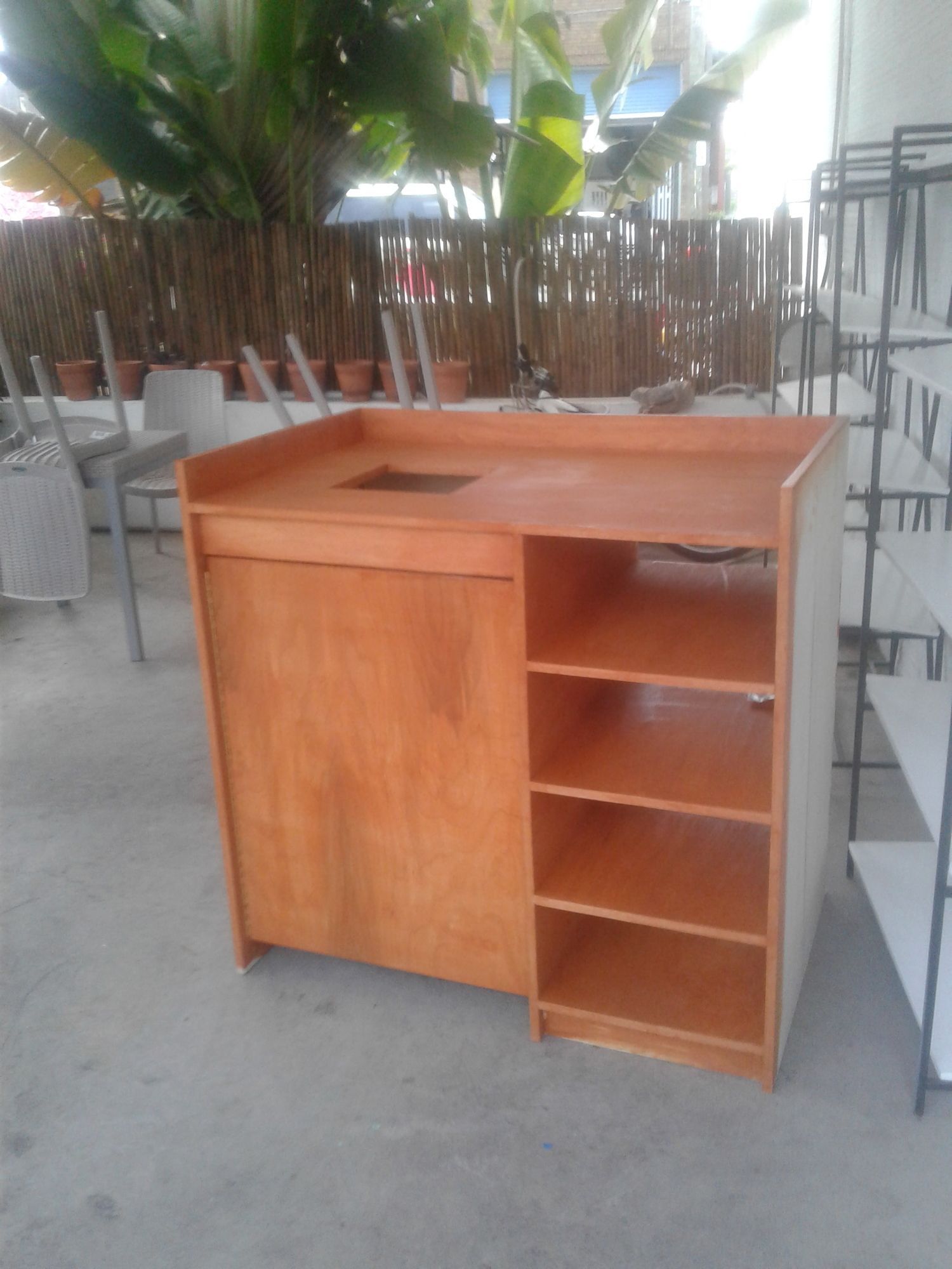 a wooden cabinet with shelves and a sink