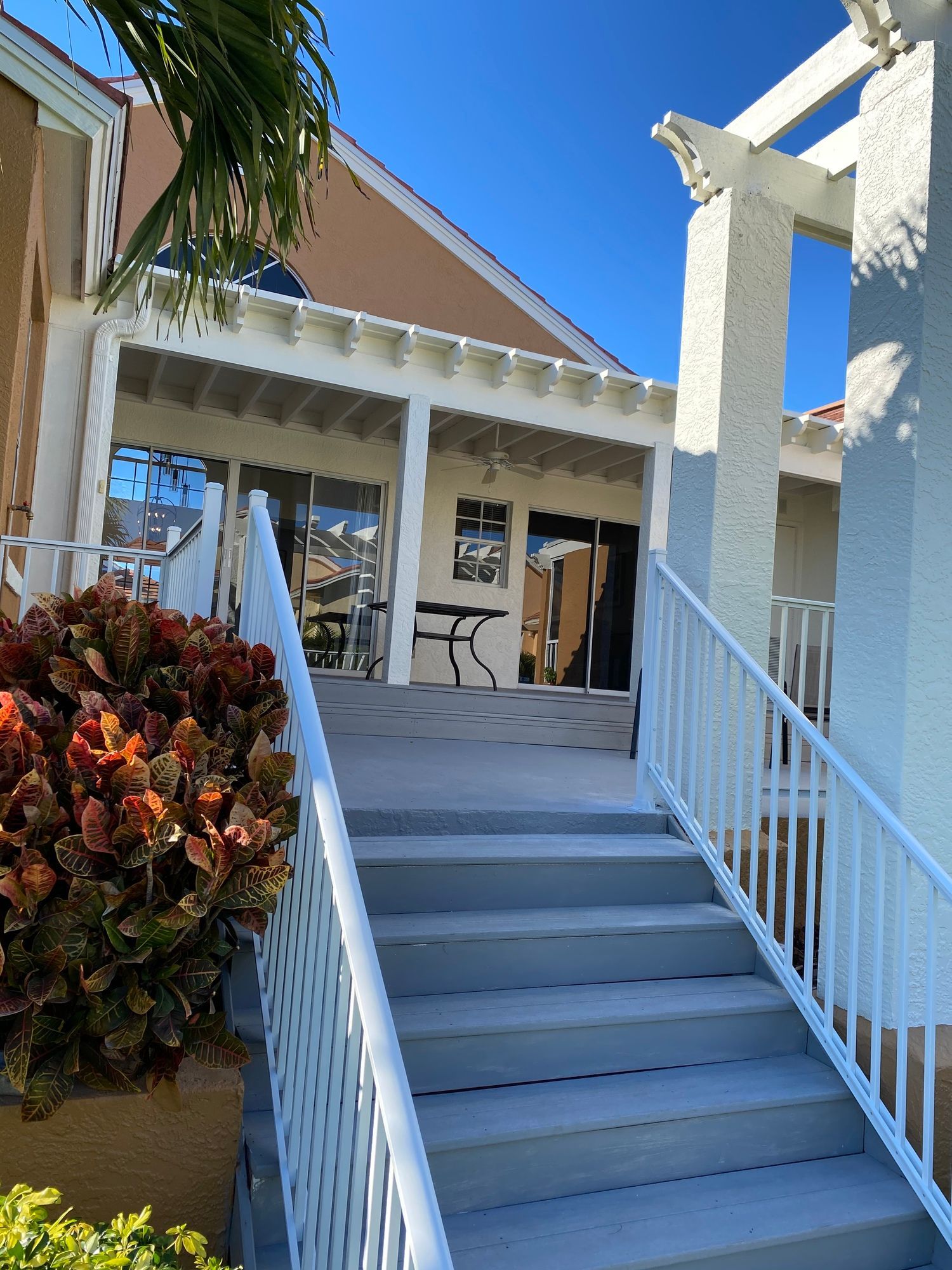 stairs leading up to a porch with a white railing