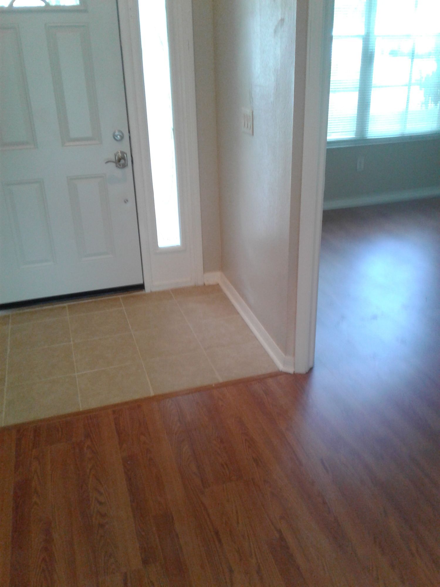 a hallway with hardwood floors and a white door