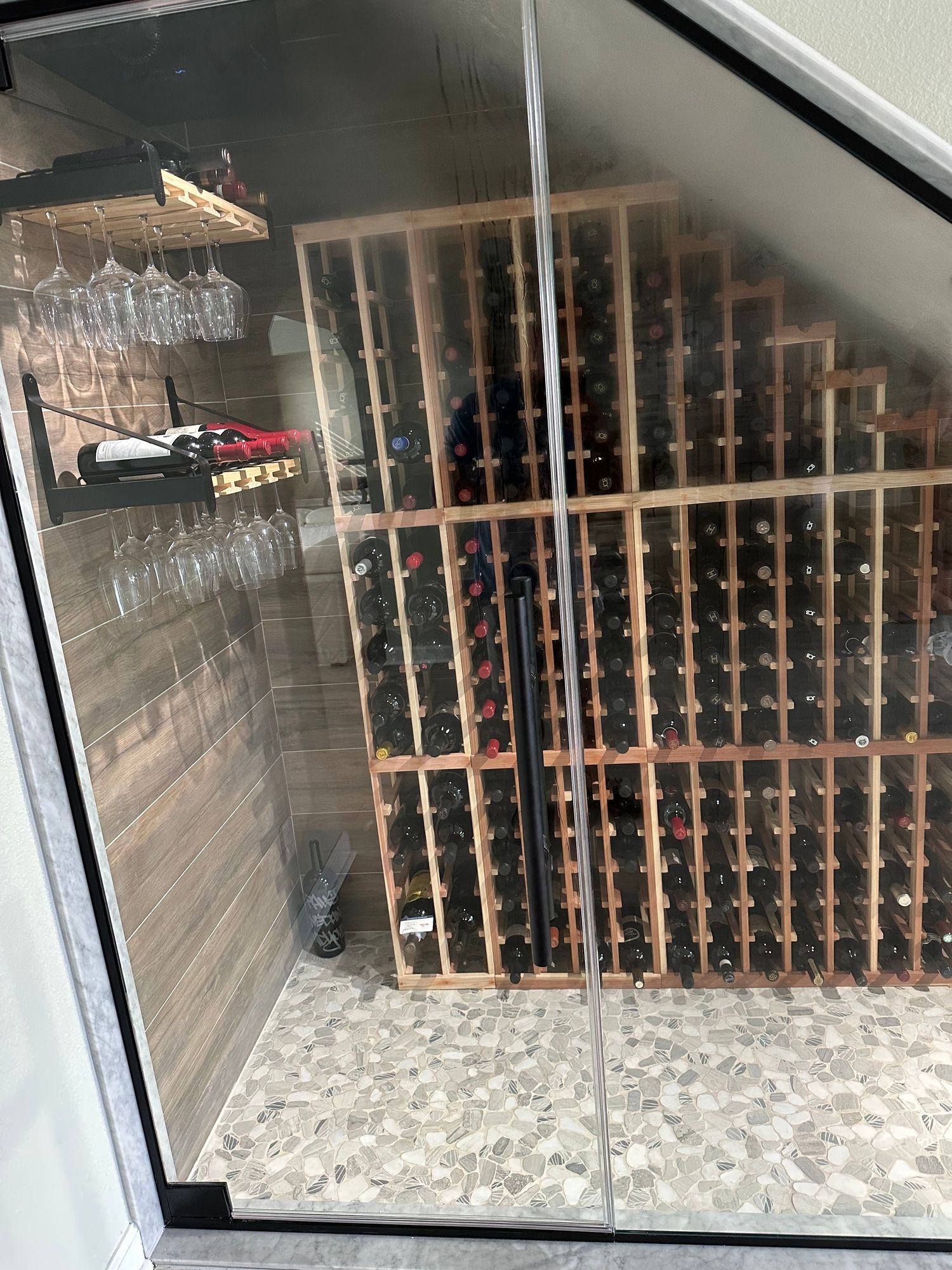 a wine cellar filled with lots of wine bottles and glasses .