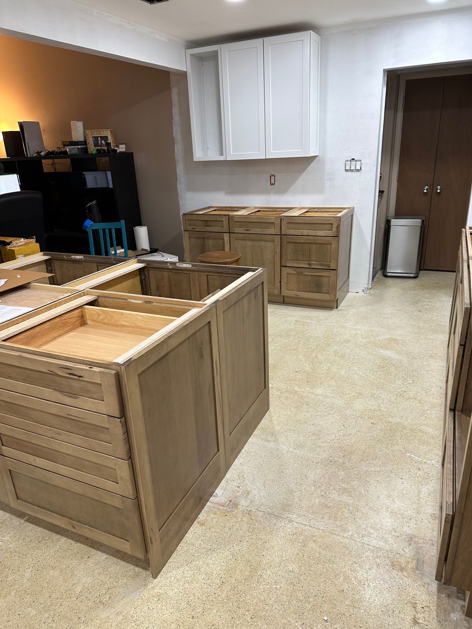 a kitchen under construction with wooden cabinets and drawers .