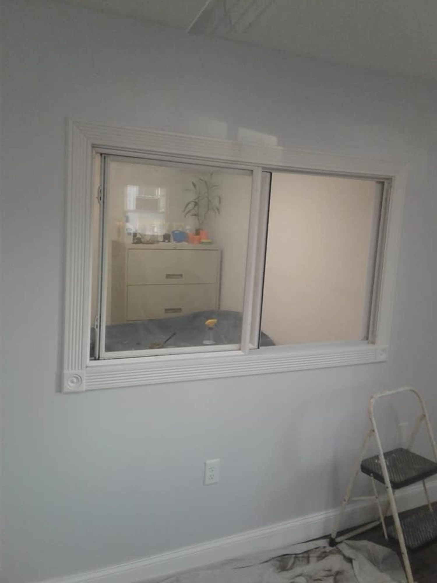 a room with a window and a ladder in it .