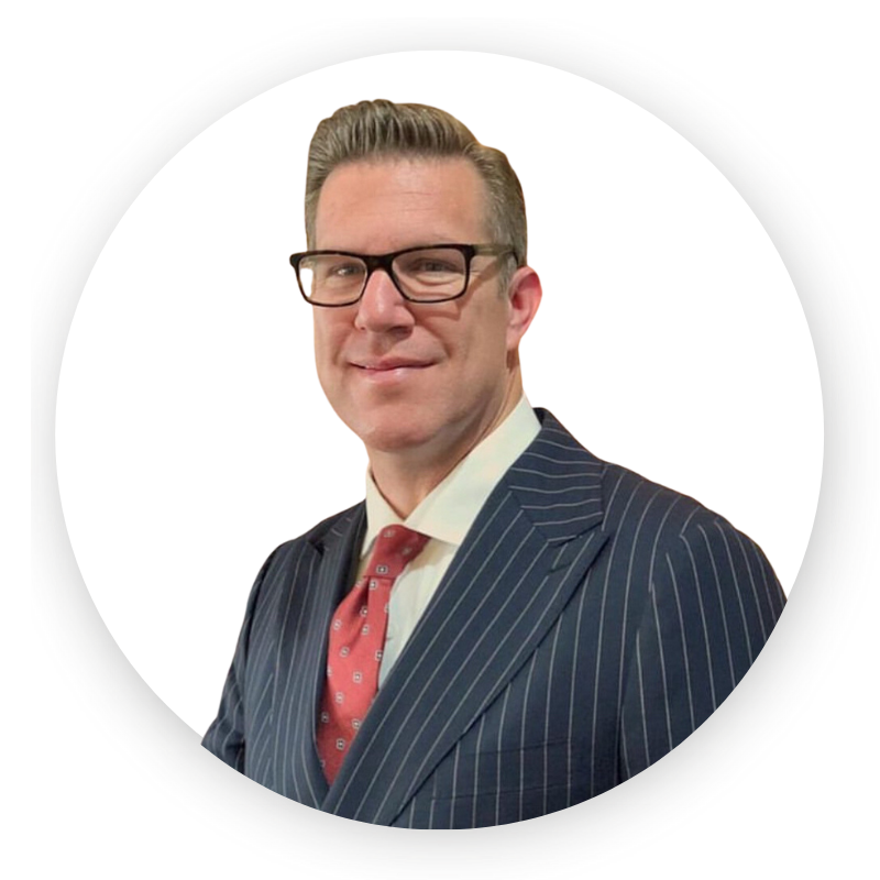 A man in a suit and tie is smiling for the camera