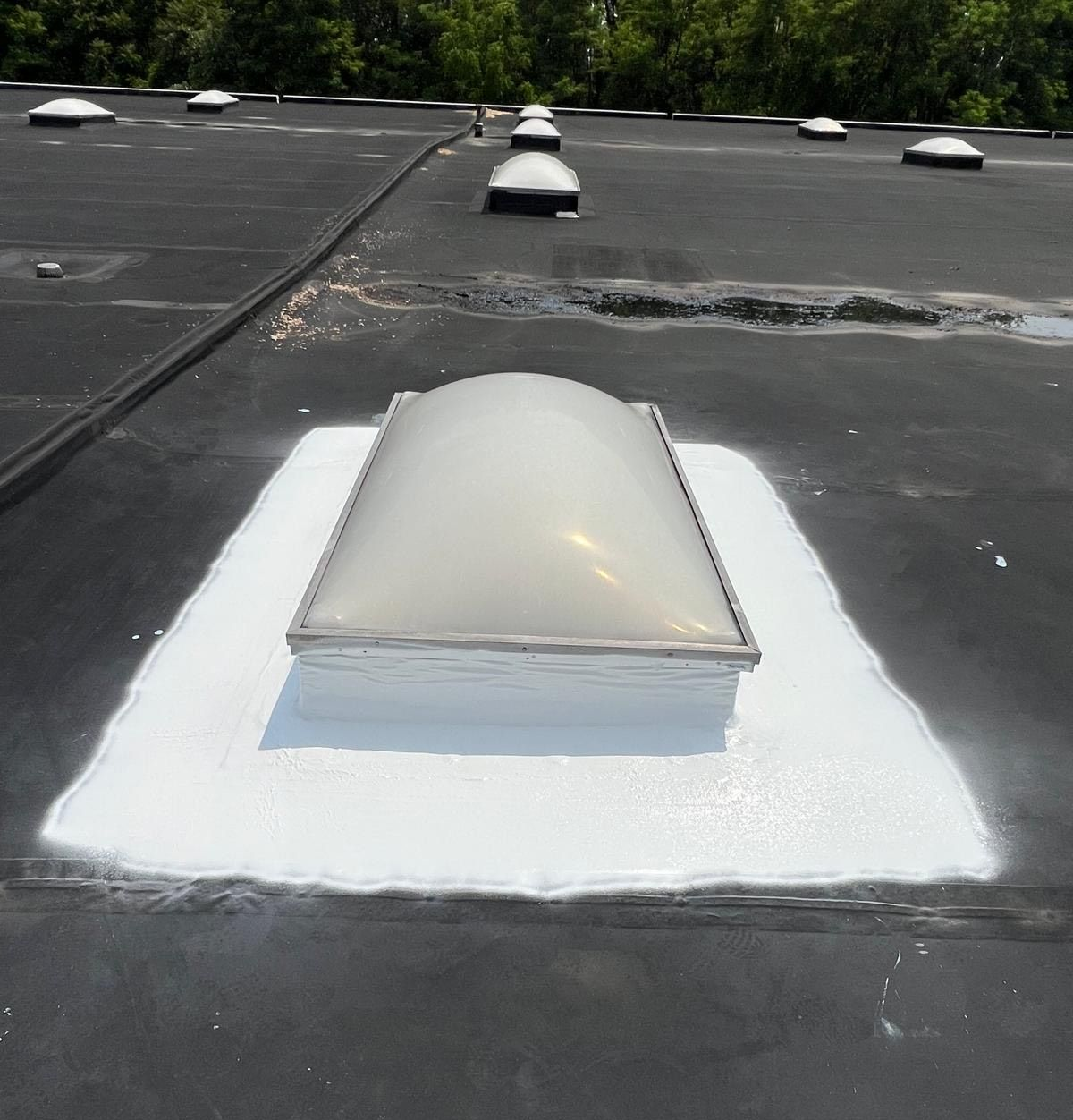 Person using a torch to install roofing material on a white surface. Person using a torch to install roofing material on a white surface.