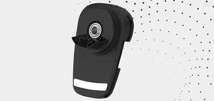 A black object with a white stripe on the side is sitting on a white surface.