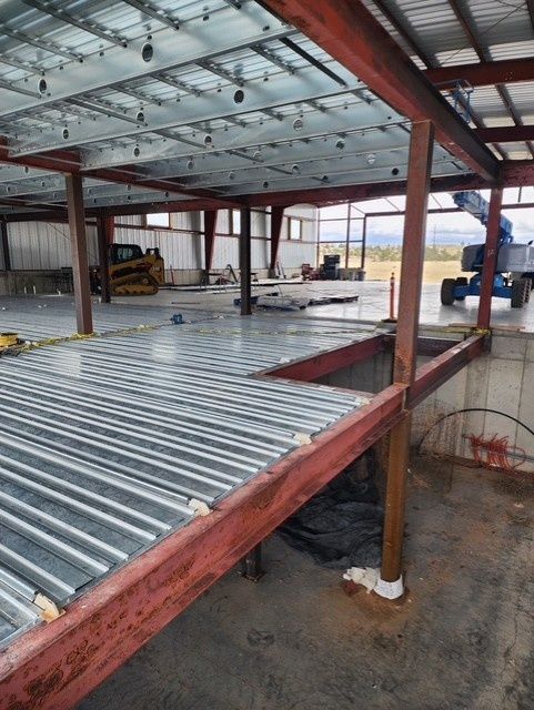 Roofers installing metal roofing sheets on a cloudy day.