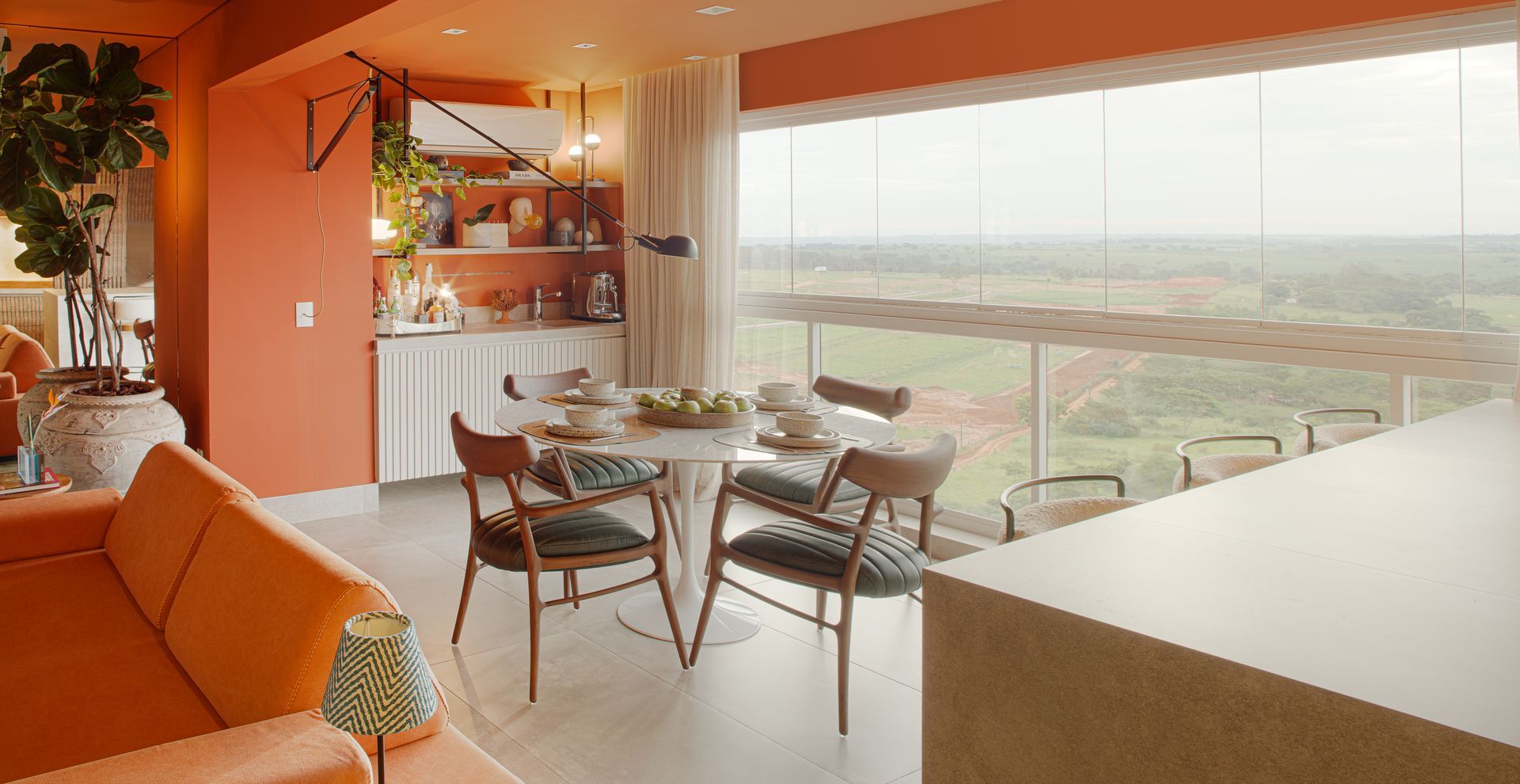Uma sala de estar com mesa de jantar e cadeiras e uma grande janela.