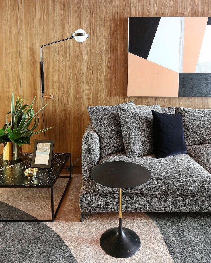 Uma sala de estar com sofá, mesa de centro e quadro na parede.