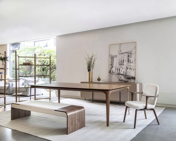 Uma sala com mesa e cadeiras e um banco.