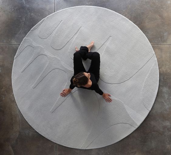Uma pessoa está deitada em um tapete circular branco
