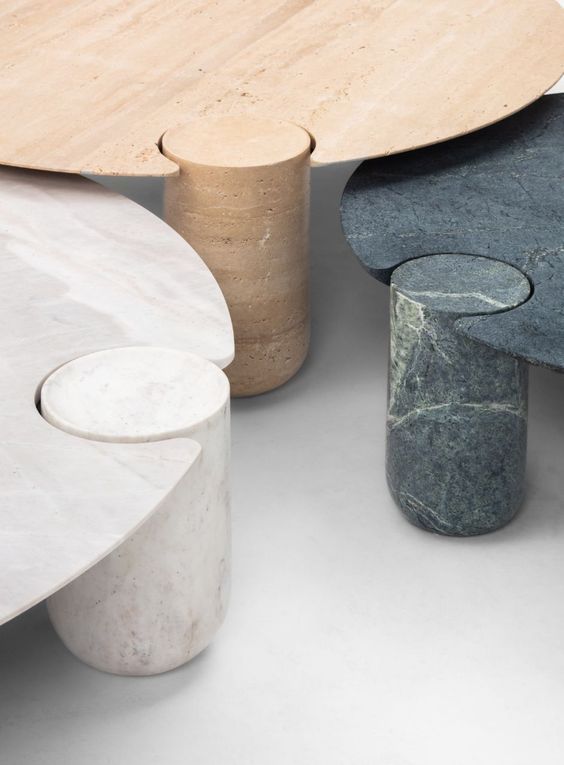 Três mesas feitas de materiais diferentes estão colocadas uma ao lado da outra sobre uma mesa.