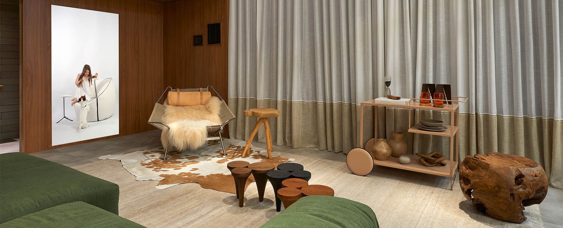 Uma sala com sofá, cadeiras, mesas e carrinho.