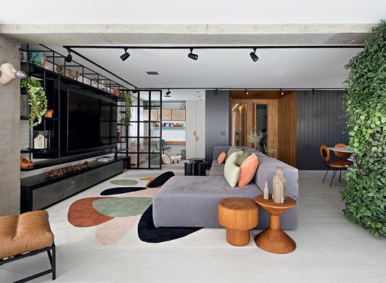 Uma sala de estar com sofá, cadeira, mesa e televisão.