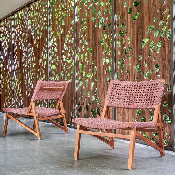 Duas cadeiras estão sentadas em frente a uma parede de madeira
