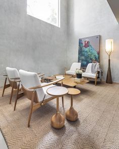 Uma sala com cadeiras, mesas e um quadro na parede.