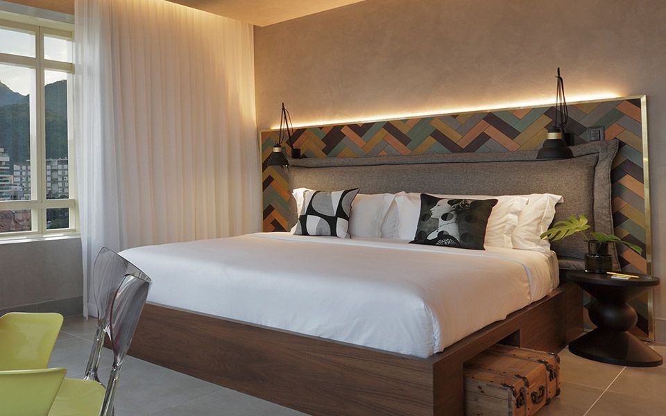 Um quarto de hotel com cama king size e uma grande janela.