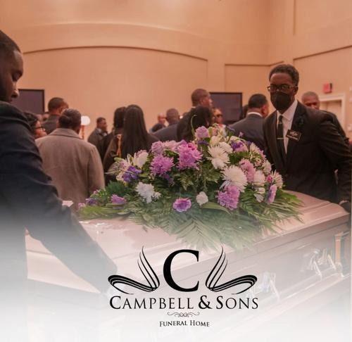 Floral casket at a funeral home service, with mourners standing nearby and Campbell & Sons logo overlay.