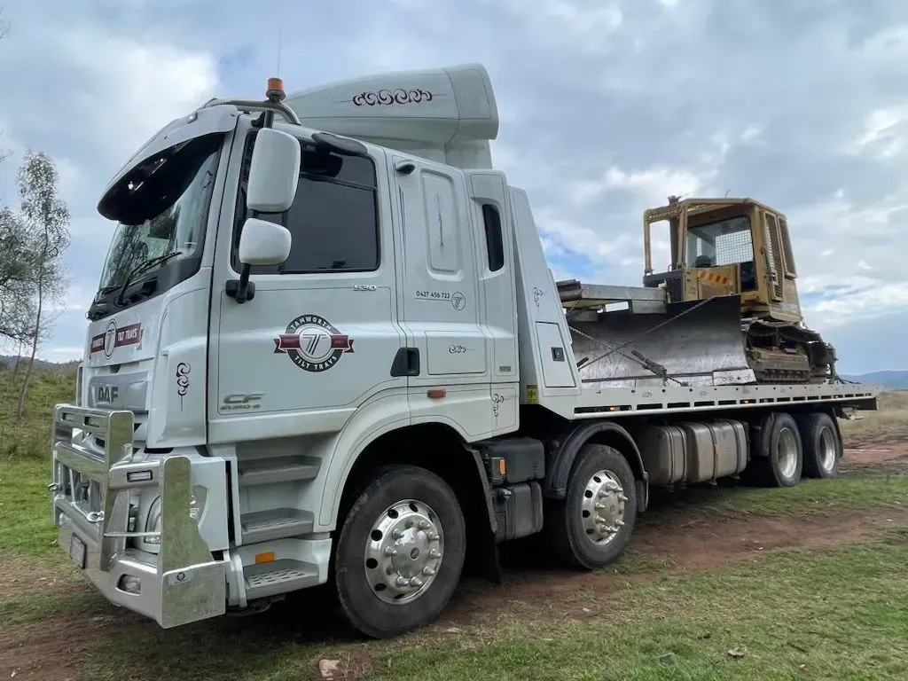 A White Flatbed Truck Parked on a Grassy Field — Tamworth Tilt Trays in Tamworth, NSW