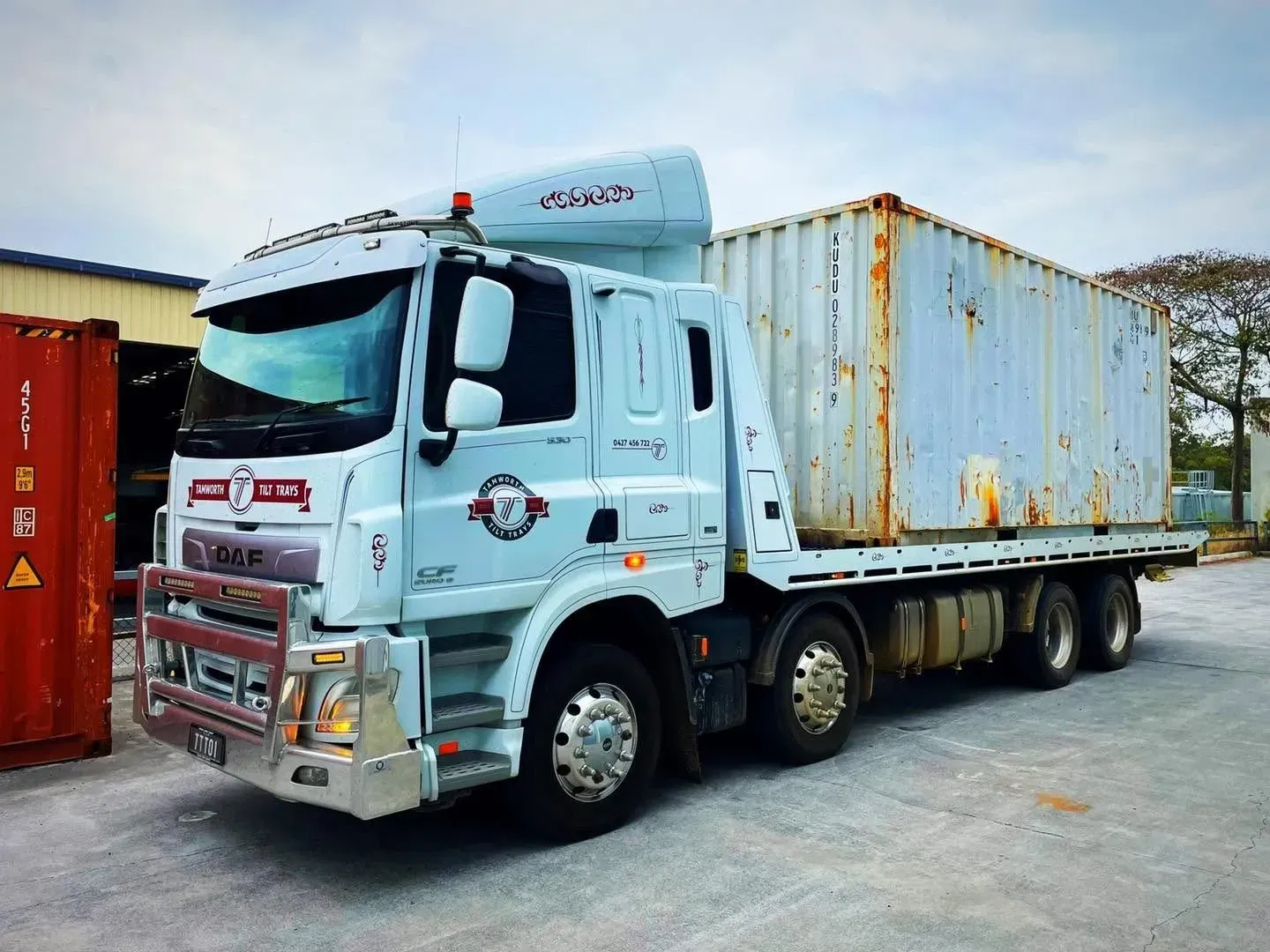 A White DAF Flatbed Truck Carrying a Weathered Shipping Container — Tamworth Tilt Trays in Tamworth, NSW