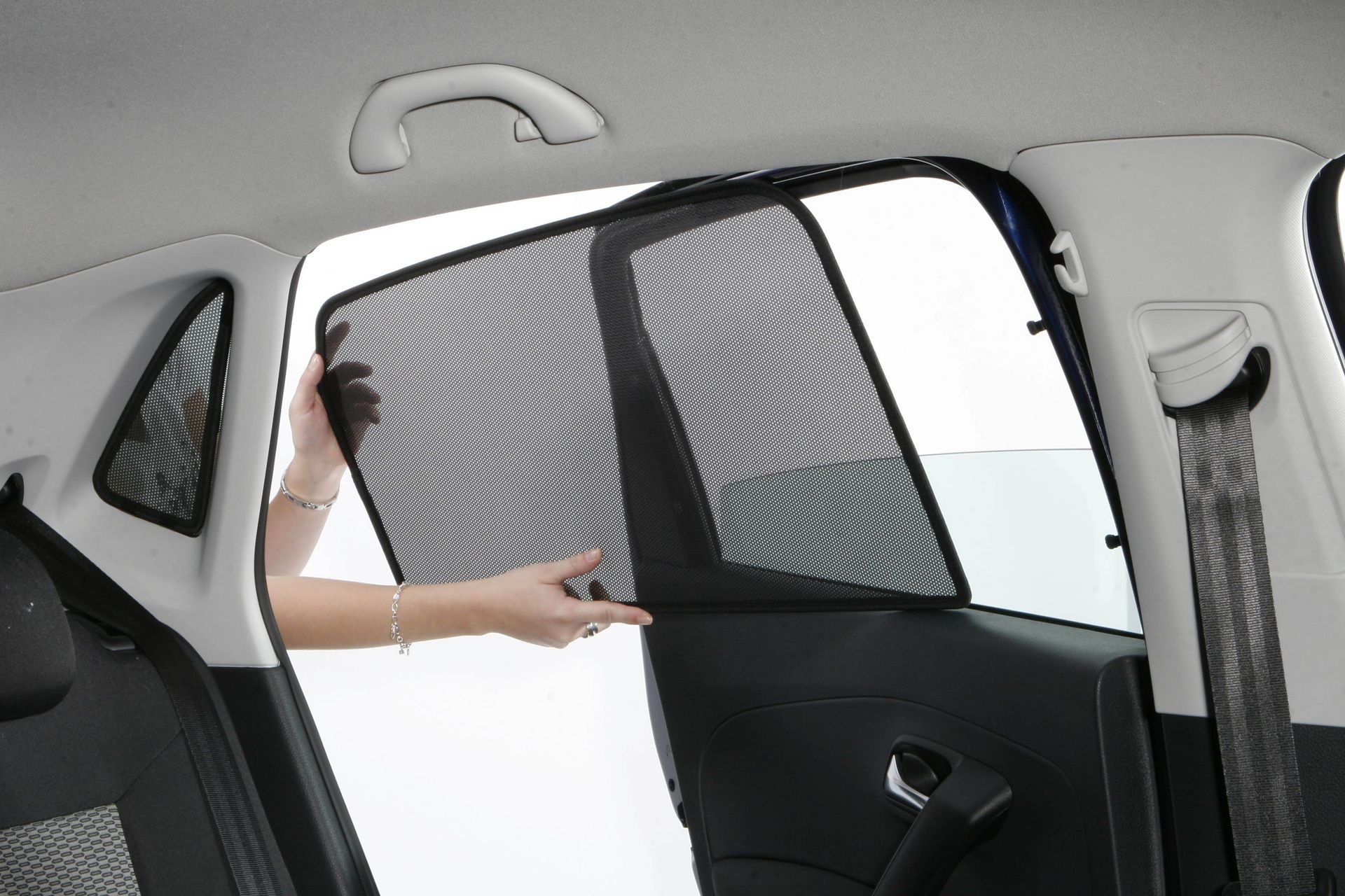 A person is opening the back door of a car