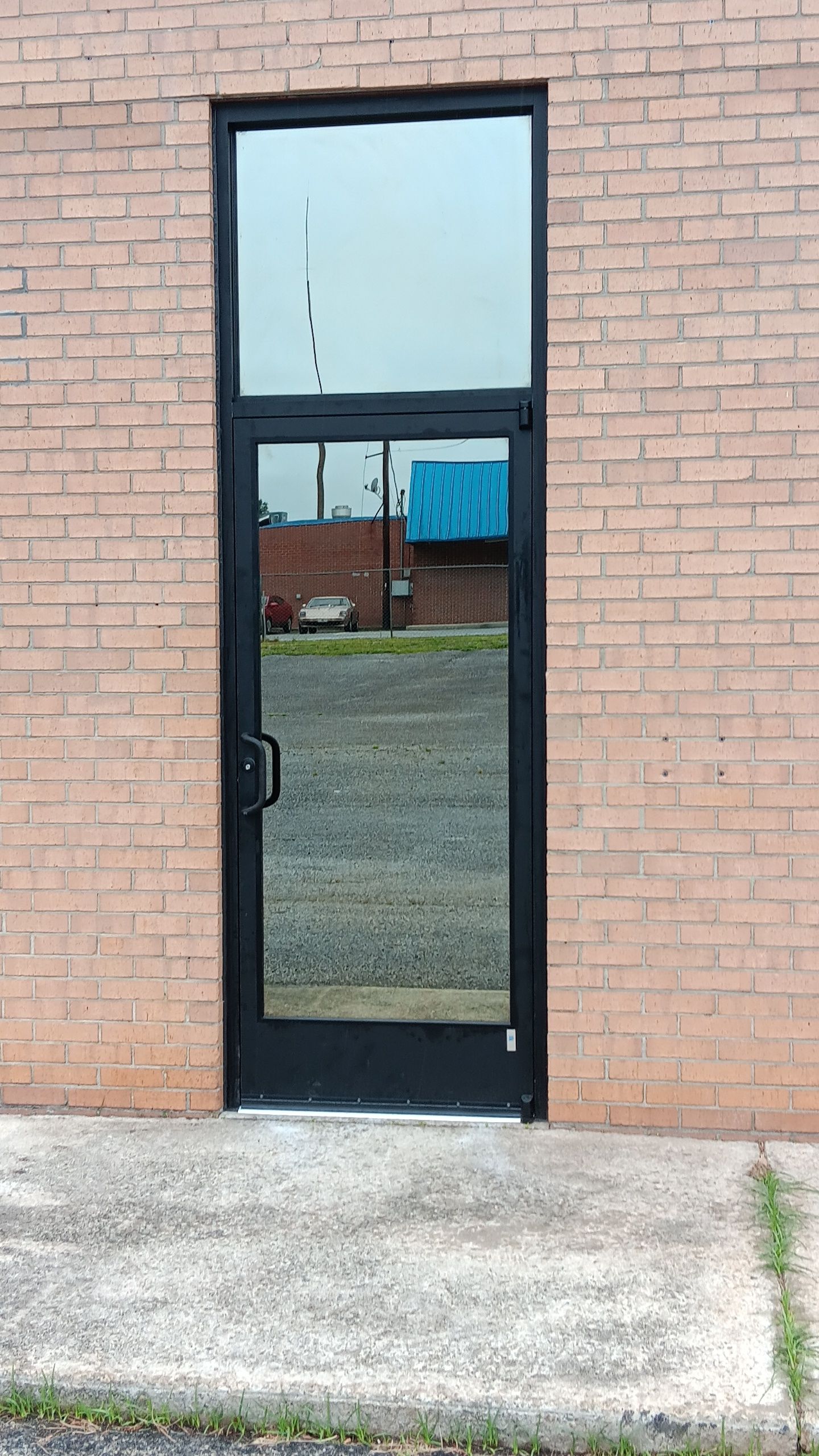 A black door is on the side of a brick building.
