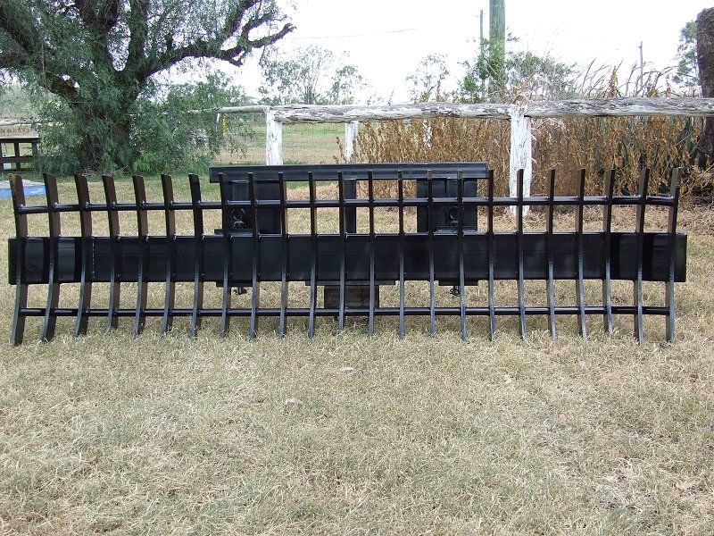 A black fence is sitting in the middle of a grassy field