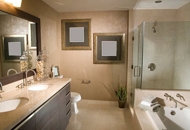 Modern bathroom with double vanity, large mirror, toilet, bathtub, and glass shower.