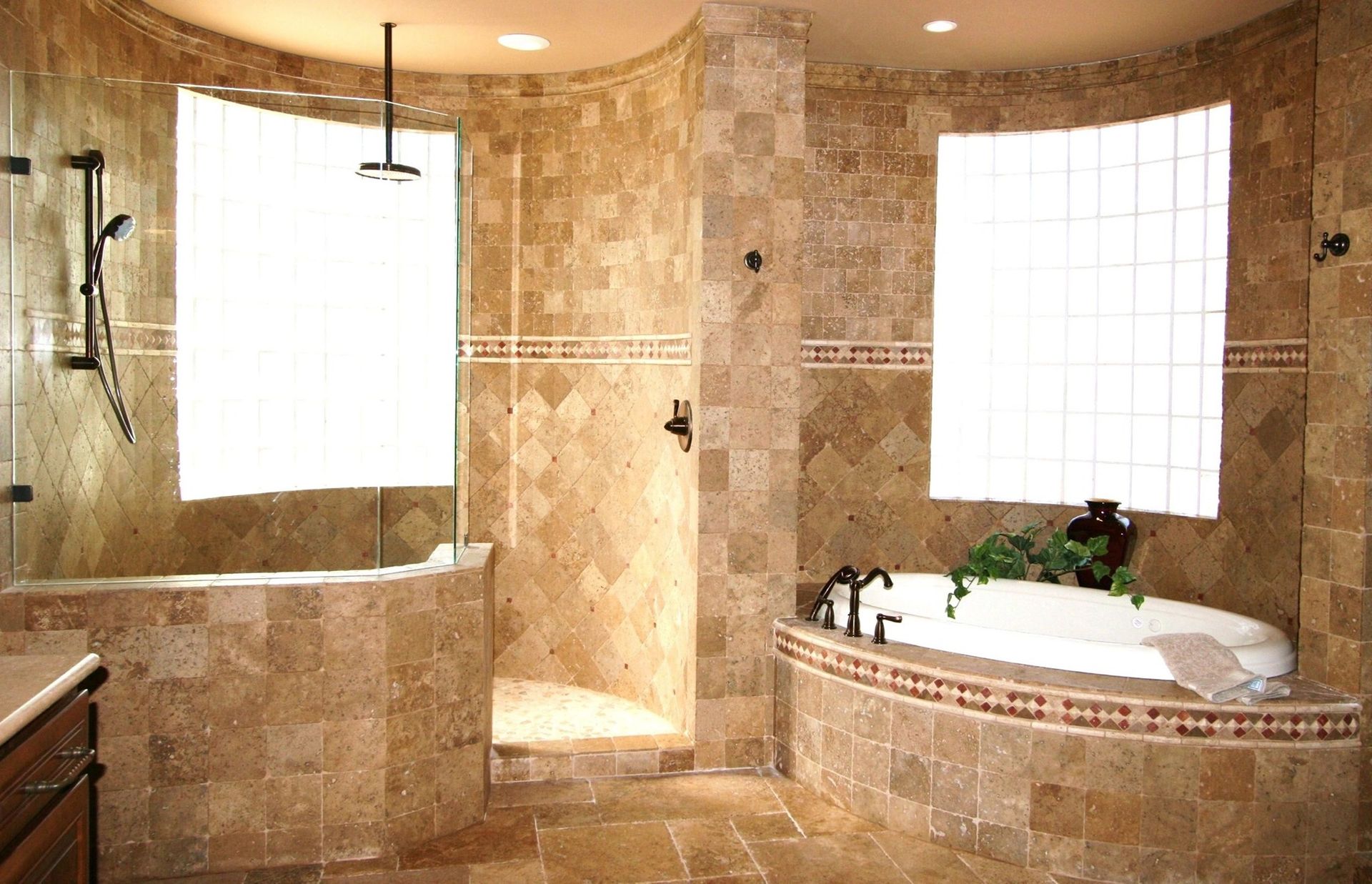 Spacious beige tiled bathroom with large windows, a soaking tub, and a glass-enclosed shower.