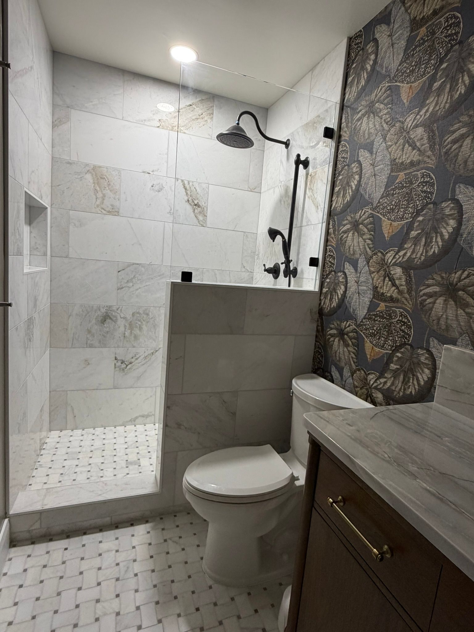 Modern bathroom with walk-in shower, white tile walls, gray partition, and dark vanity vanity cabinet