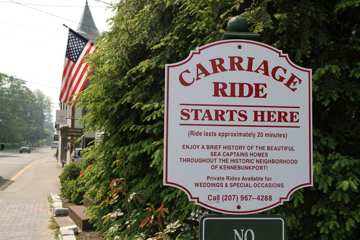 Sign for carriage rides: red text on white, reads 