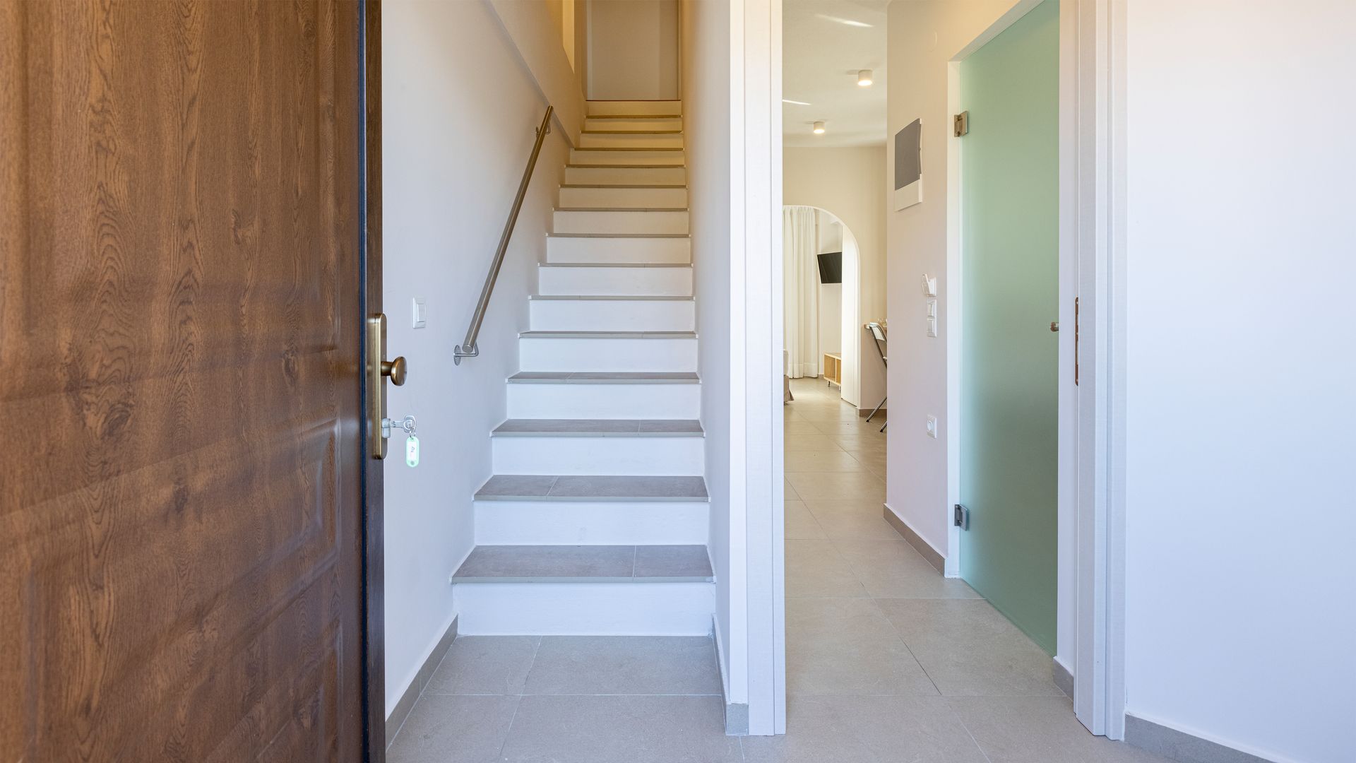 A hallway with stairs leading up to the second floor of a house.