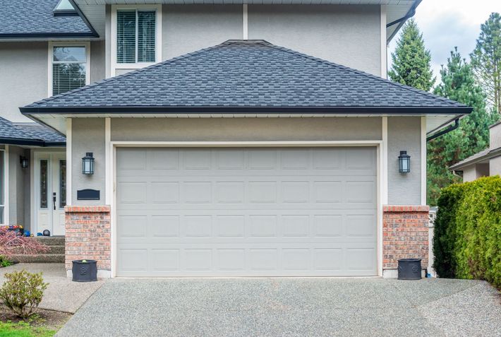 A large house with a garage door and a driveway.