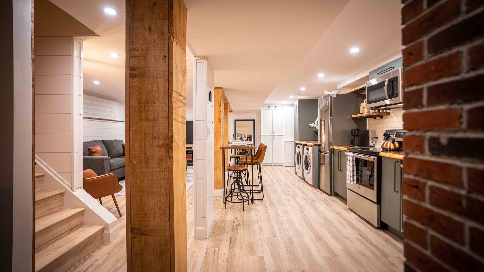 the kitchen, appliances, fridge, stove, and stairs coming into the unit, wooden rectangular dining table and high chairs