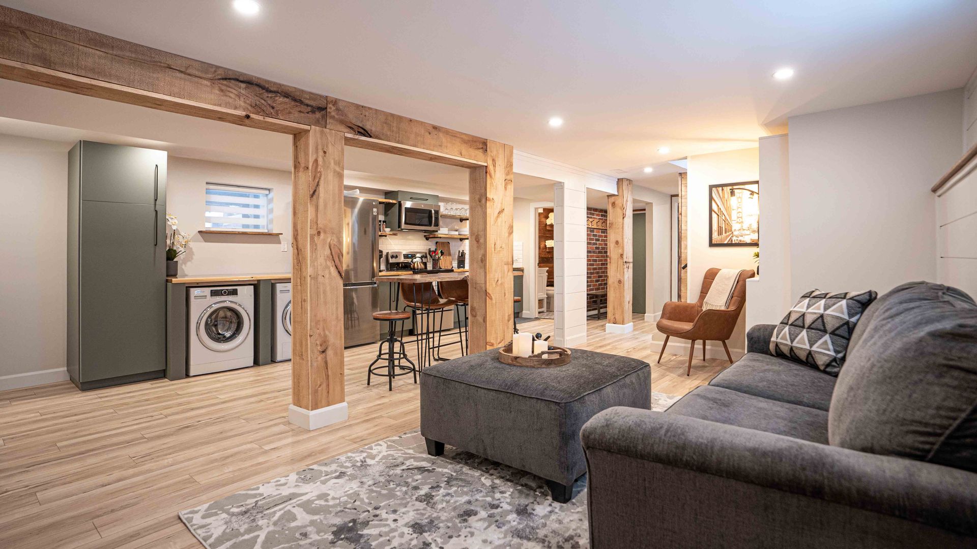 the kitchen, appliances, fridge, stove, wooden rectangular dining table, high chairs, grey sofa in foreground