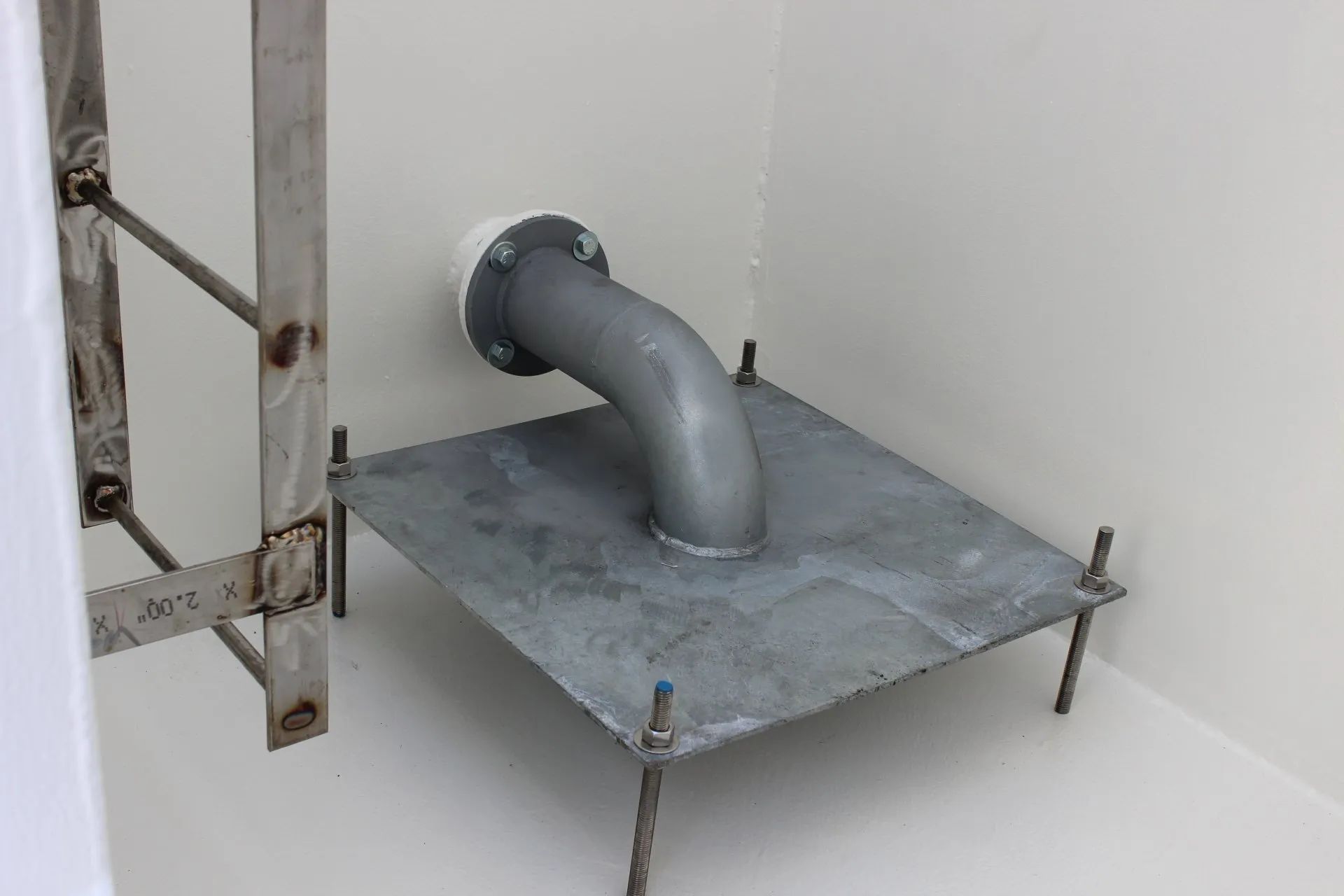 A pipe is sitting on top of a metal plate in a room.