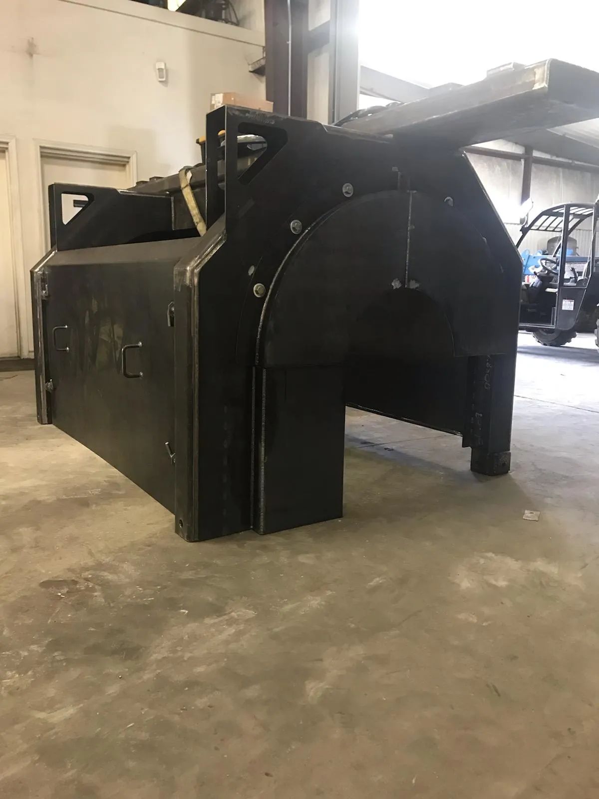A large black box is sitting on the floor in a garage.