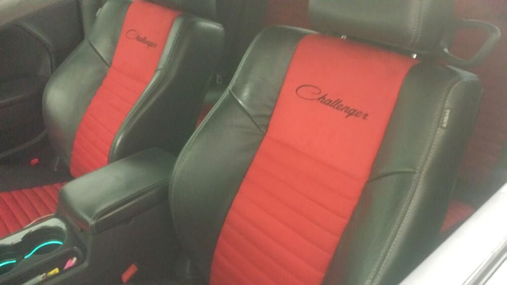 The seats of a dodge challenger are red and black